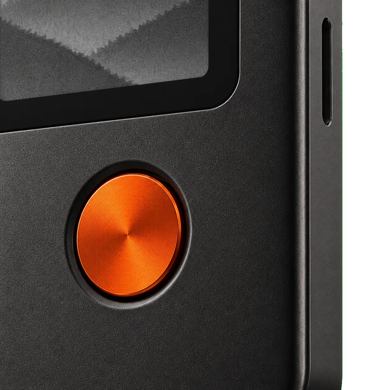 Macro view of Cinder's ember-orange confirmation button and side control